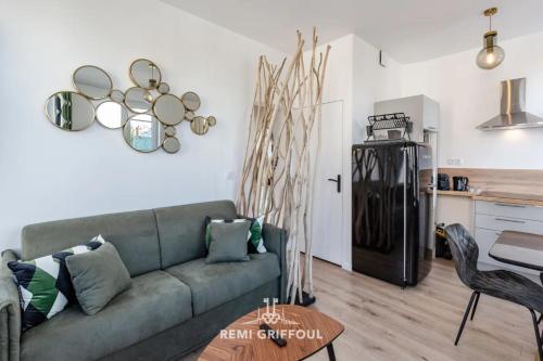 un salon avec un canapé et une cuisine dans l'établissement Le Vannier Private Garage Balcony 2 Guests, à Honfleur