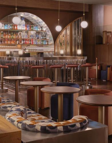 a restaurant with tables and chairs and a bar at Public House Bangkok, a Member of Design Hotels in Bangkok