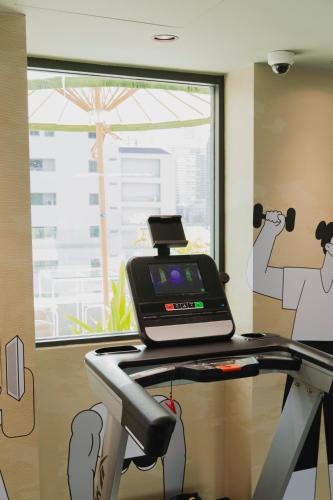 a treadmill in a room with a window at Public House Bangkok, a Member of Design Hotels in Bangkok