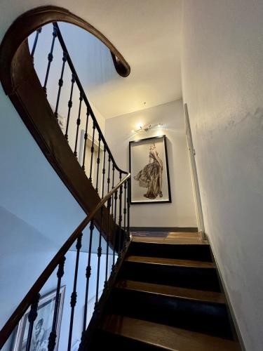 a staircase in a house with a picture on the wall at Les Lys D'or vue Château Hyper Centre climatisé in Saumur