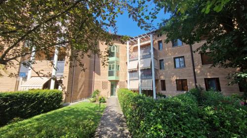 a large brick building with a walkway in front of it at La Casa di Cami in Agrate Brianza