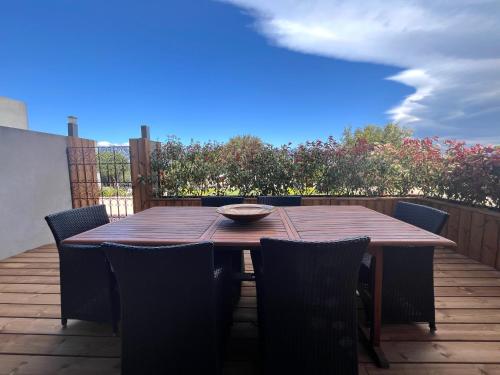 a wooden table and chairs on a wooden deck at Résidence Storia di Blue in Porto-Vecchio