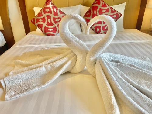 two swans wrapped in towels on a bed at Lipe Urban Homestay in Ko Lipe