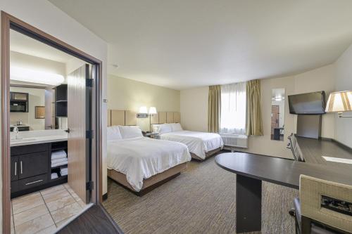 タルサにあるAffordable Suites of America Tulsaのベッド2台とバスルームがあるホテルの部屋