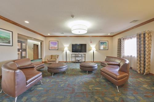 a waiting room with leather furniture and a flat screen tv at Affordable Suites of America Tulsa in Tulsa