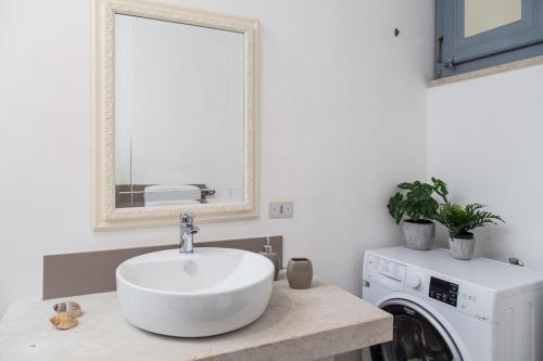 a bathroom with a sink and a washing machine at Historical Palace apartament in Marsala