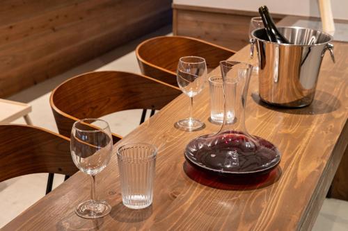 a wooden table with four wine glasses and a bucket at Mameyama15 in Nara
