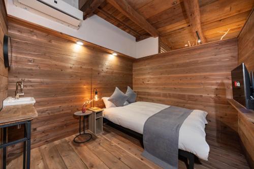 a bedroom with wooden walls and a bed in a room at Mameyama15 in Nara