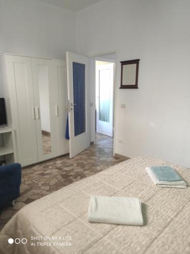 a white bedroom with a bed and a mirror at Casa di Ana 2 in Ancona