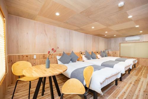 a room with two beds with a table and a tableasteryasteryasteryasteryastery at Mameyama15 in Nara