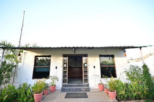 a white house with plants in front of it at The castle crown - Hem Vilas Resort Ranthambhore in Sawāi Mādhopur