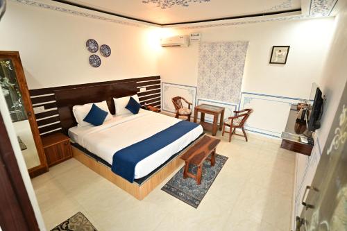 a bedroom with a bed and a table and chairs at The castle crown - Hem Vilas Resort Ranthambhore in Sawāi Mādhopur