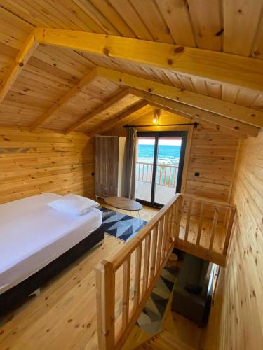 a bedroom in a log cabin with a bed and a window at Manzara Bungalow in Demre