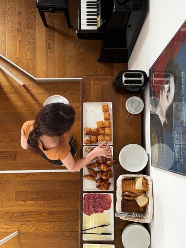 a woman is standing next to a tray of food at Tric Trac Hostel in Naples