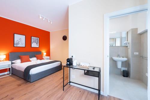 a bedroom with orange walls and a bed and a sink at La Nuova Corte Rooms in Verona