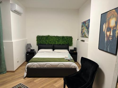 a bedroom with a bed and a black chair at Flat with Jacuzzi - Casa Pia in Mondello