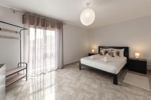 a bedroom with a bed and a large window at Moradia Marques in Nazaré