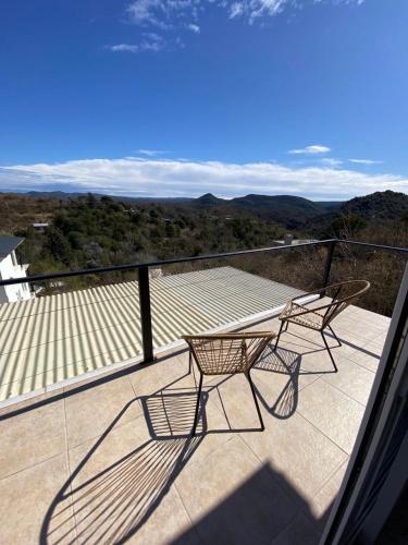 a patio with two chairs and a table on a balcony at Aire de las Sierras in Embalse