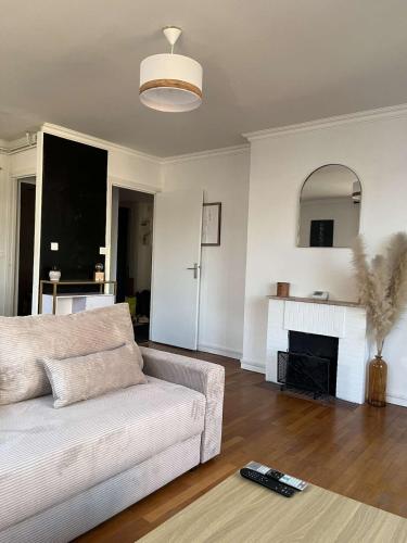 un salon avec un canapé et une cheminée dans l'établissement Chaleureux T2 à La Plage du Havre, au Havre