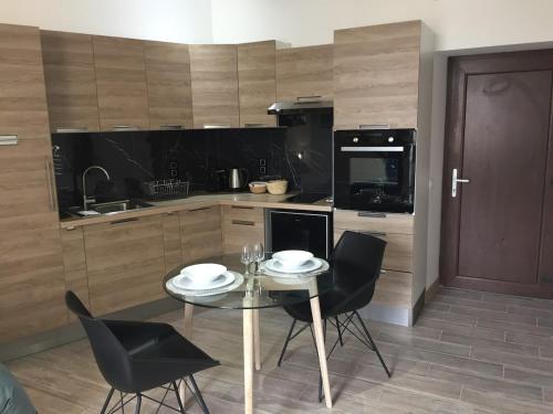 une cuisine avec une table et des chaises dans une cuisine dans l'établissement Studio centre ville avec vue sur les toits, à Nîmes