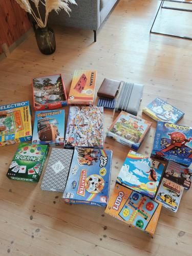 a pile of books sitting on a wooden floor at EchoBay nr 2 - child-friendly house close to the beach in Jerup