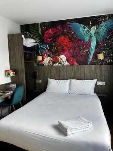 Un dormitorio con una cama con un cuadro en la pared. en Hotel Eden, en Saint-Malo
