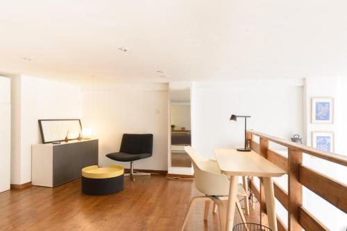 a living room with a table and chairs at Rue du Centre - Lumineux appartement duplex Centre Montreux in Montreux