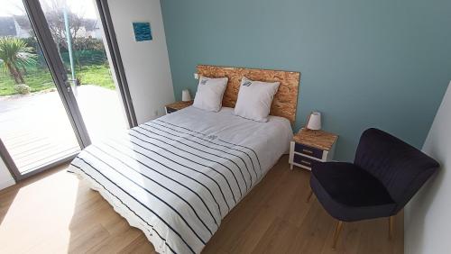 une chambre avec un lit, une chaise et une fenêtre dans l'établissement New house near ria and beach, à Plouhinec