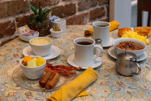 a table topped with cups of coffee and breakfast foods at The Marshall House, Historic Inns of Savannah Collection in Savannah