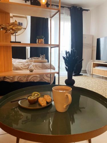 - une table basse avec une tasse et une assiette de nourriture dans l'établissement 'L'Élégant' Studio Centre, Parking privé, Clim, Terrasse, à Sète