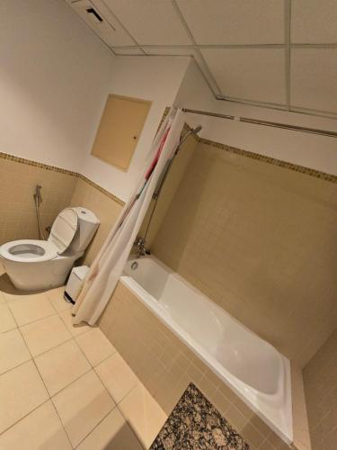 a bathroom with a toilet and a bath tub at النزهة2 in Cairo