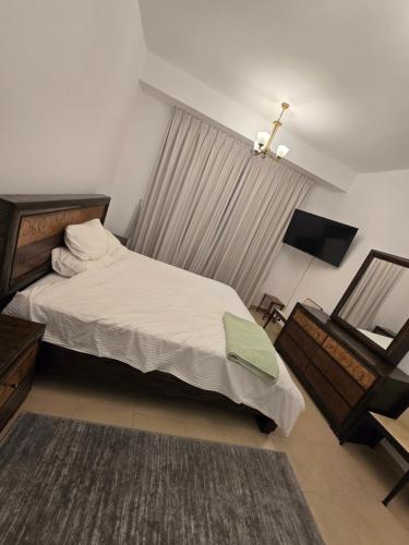 a bedroom with a large bed and a mirror at النزهة2 in Cairo