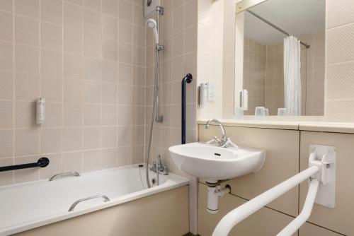 a bathroom with a sink and a bath tub at Days Inn Hotel Sedgemoor in Rooks Bridge