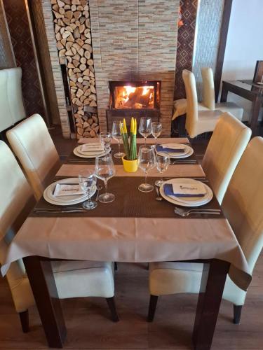 a dining room table with chairs and a fireplace at Hotel Domestika in Skopje