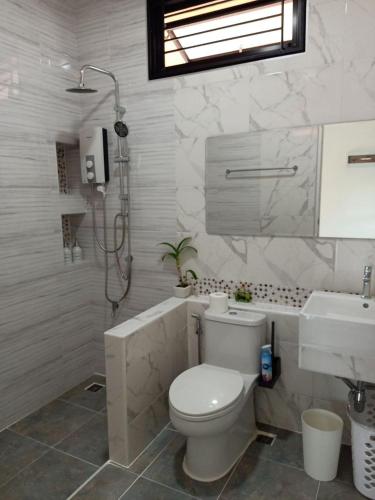 a bathroom with a toilet and a sink and a shower at Gold Rock Villa in Ban Nam Luat