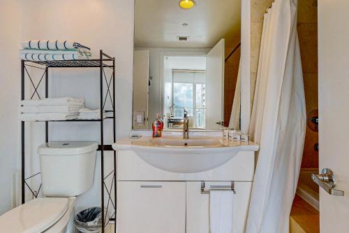 ein Badezimmer mit Waschbecken, Toilette und Spiegel in der Unterkunft Iconic Views in Miami