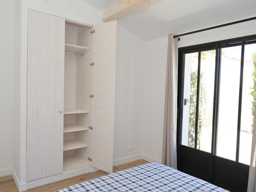 - une chambre avec des murs blancs, un lit et une fenêtre dans l'établissement Maison de plain-pied avec Parking et Climatisation près de Châtelaillon-Plage - FR-1-706-33, à Saint-Vivien