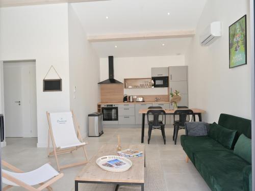 un salon avec un canapé vert et une table dans l'établissement Maison plain pied avec parking et climatisation à Saint-Vivien - FR-1-706-35, à Saint-Vivien