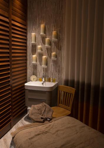 a bathroom with a sink and a bed with a chair at Ilsington Country House Hotel & Spa in Ilsington