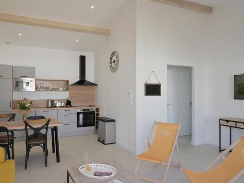 une cuisine et un salon avec une table et des chaises dans l'établissement Maison plain-pied 53m² avec terrasse et parking à St-Vivien - FR-1-706-36, à Saint-Vivien