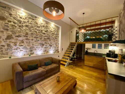un salon avec un canapé et un mur en pierre dans l'établissement 'Le loft' Jacuzzi standing en centre ville, à Sète