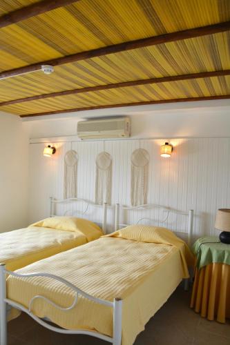 a bedroom with two beds and a wooden ceiling at SOLAR DOS AVÓS in Guia