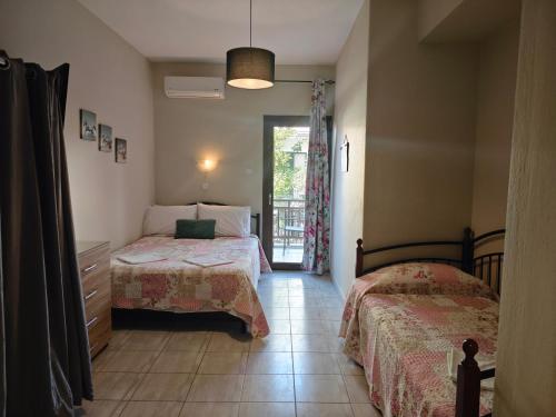 a bedroom with two beds and a door to a balcony at House Anna Sarti in Sarti