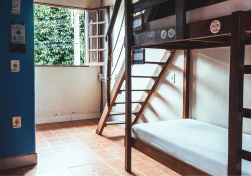 a room with two bunk beds and a window at Maresias Hostel & Suites in Maresias