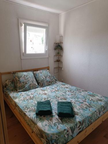 une chambre avec un lit avec deux oreillers verts dessus dans l'établissement les sables d'or grau du roi, au Grau-du-Roi