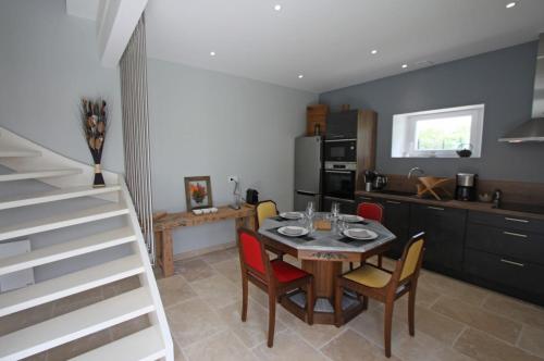 une cuisine et une salle à manger avec une table et des chaises dans l'établissement Gîte de La Madone, à Rémoville