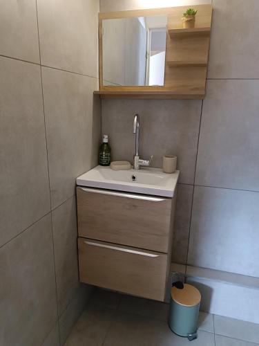 une salle de bain avec un lavabo et un miroir dans l'établissement les sables d'or grau du roi, au Grau-du-Roi