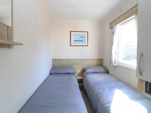 two beds in a small room with a window at 31A Foxburrow Hang in Great Yarmouth