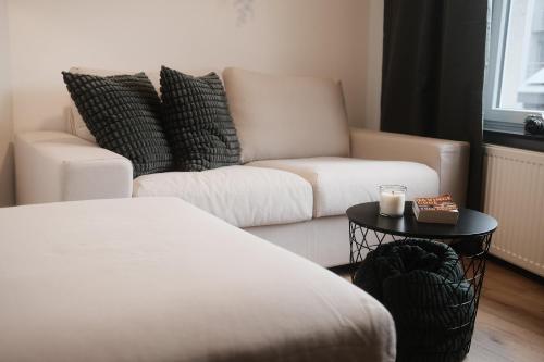 a living room with a couch and a table with a candle at Félix le chat ll in La Roche-en-Ardenne