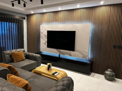 a living room with a large flat screen tv at Seaside Serenity Maisonette - Private Pool in St. Paul's Bay
